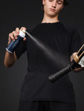 Cargar la imagen en la vista de la galería, Aplicación de spray agarre Velaz MaxGrip sobre el overgrip de una pala de pádel.