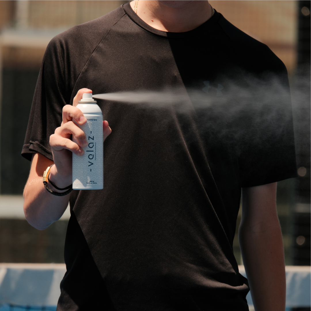Primer plano de la mano de un deportista rociando spray antideslizante Velaz TotalGrip de 200ml para secar las manos.
